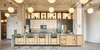 Modern home with Kitchen, Quartzite Counter, Wood Cabinet, Light Hardwood Floor, Stone Slab Backsplashe, Ceiling Lighting, Recessed Lighting, Accent Lighting, Refrigerator, Wall Oven, Range Hood, Cooktops, Dishwasher, Microwave, and Undermount Sink. Kitchen view from dining room. Photo of West Loop Residence