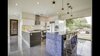 Modern home with Kitchen, White Cabinet, Ceramic Tile Floor, Ceramic Tile Backsplashe, Ceiling Lighting, Refrigerator, Cooktops, Microwave, and Dishwasher. Kitchen with an island of recycled sky blue vodka bottles in concrete. Photo 6 of The Peña Home