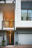 Modern home with House Building Type, Stucco Siding Material, Small Patio, Porch, Deck, Metal Fences, Wall, Metal, Exterior, Swing Door Type, Attached Garage Room Type, and Outdoor. Homes are six to eight inches apart. The gap is covered with an expansion joint metal to allow movement of each structurally independent home in the event of an earthquake. The expansion joints also serve as protection from the elements. Photo 4 of COVO