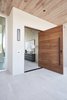 Modern home with Exterior, Concrete Siding Material, Mid-Century Building Type, House Building Type, Prefab Building Type, and Wood Siding Material. A solid-wood door welcomes guests from the covered front patio into the protected foyer. Photo 4 of BUILDER Chōwa Concept Home