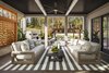 Glass pocket doors tuck neatly into the wall serving to connect the indoor and outdoor living rooms. Warm wood flooring flows from the interior to the exterior creating a seamless transition. Photo 4 of Retreat at McLean and Mehr Farm modern home