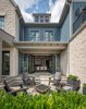The contemporary farmhouse juxtaposes textures of light dry-stack stone adjacent to metal canopies and dark bronze windows. Photo 8 of Retreat at McLean and Mehr Farm modern home