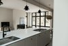 Modern home with Kitchen, Engineered Quartz Counter, Concrete Floor, Range, Dishwasher, Undermount Sink, and Pendant Lighting. View from kitchen island to great room with steel mantel fireplace and floor-to-ceiling windows. Photo 3 of North Shore #7