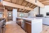 Modern home with Kitchen, Engineered Quartz Counter, Quartzite Counter, Wood Cabinet, Medium Hardwood Floor, Ceiling Lighting, Pendant Lighting, Refrigerator, Range, Dishwasher, and Undermount Sink. Quartz waterfall counter large enough to seat 5 Photo 7 of Mammoth Modern House 1