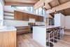 Modern home with Kitchen, Engineered Quartz Counter, Quartzite Counter, Wood Cabinet, Medium Hardwood Floor, Ceiling Lighting, Pendant Lighting, Refrigerator, Range, and Undermount Sink. High, wood ceilings and clerestory windows Photo 9 of Mammoth Modern House 1