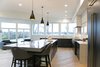 Modern home with Kitchen, Engineered Quartz Counter, Quartzite Counter, White Cabinet, Wood Cabinet, Light Hardwood Floor, Pendant Lighting, Dishwasher, Ceiling Lighting, Accent Lighting, Refrigerator, Microwave, Cooktops, Range, Range Hood, and Drop In Sink. Sea Star Kitchen - After Photo of Sea Star - Modernization Transformation