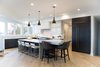 Modern home with Kitchen, Engineered Quartz Counter, Quartzite Counter, White Cabinet, Wood Cabinet, Light Hardwood Floor, Ceiling Lighting, Pendant Lighting, Accent Lighting, Refrigerator, Microwave, Dishwasher, Cooktops, Range, Range Hood, and Drop In Sink. Sea Star Kitchen - After Photo 2 of Sea Star - Modernization Transformation