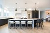 Modern home with Kitchen, Engineered Quartz Counter, Quartzite Counter, White Cabinet, Wood Cabinet, Light Hardwood Floor, Ceiling Lighting, Accent Lighting, Pendant Lighting, Refrigerator, Microwave, Dishwasher, Cooktops, Range, Range Hood, and Drop In Sink. Sea Star Kitchen - After Photo 8 of Sea Star - Modernization Transformation