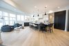 Modern home with Kitchen, Refrigerator, Microwave, Dishwasher, Range Hood, Cooktops, Range, White Cabinet, Ceiling Lighting, Accent Lighting, Pendant Lighting, Light Hardwood Floor, Wood Cabinet, Engineered Quartz Counter, and Quartzite Counter. Sea Star Kitchen - After Photo 7 of Sea Star - Modernization Transformation
