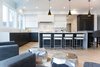 Modern home with Kitchen, Engineered Quartz Counter, Quartzite Counter, White Cabinet, Wood Cabinet, Light Hardwood Floor, Ceiling Lighting, Accent Lighting, Pendant Lighting, Refrigerator, Microwave, Dishwasher, Cooktops, Range, Range Hood, and Drop In Sink. Sea Star Kitchen - After Photo 6 of Sea Star - Modernization Transformation