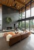 Modern home with Living Room, Accent Lighting, Concrete Floor, Standard Layout Fireplace, Ceiling Lighting, Sectional, Chair, Floor Lighting, Recessed Lighting, Wood Burning Fireplace, and Coffee Tables. Living room Photo 7 of The Greenhills House
