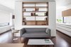 Modern home with Bedroom, Wardrobe, Night Stands, Storage, Bookcase, Chair, Bench, Shelves, Table Lighting, Pendant Lighting, Wall Lighting, Accent Lighting, and Medium Hardwood Floor. Reflecting the client and what is most important to them: a calm, refined composition that belies its more complex nature – perfectly suited to the writer in residence. Photo 5 of Coach House