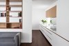 Modern home with Kitchen, Quartzite Counter, White Cabinet, Wood Cabinet, Medium Hardwood Floor, Mirror Backsplashe, and Undermount Sink. The fridge, oven and wine storage tuck away behind a swing + slide door Photo 3 of Coach House