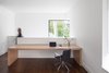Modern home with Office, Study Room Type, Library Room Type, Chair, Storage, Shelves, Lamps, Medium Hardwood Floor, and Bookcase. The long table accomodates enough room for the client’s business meetings and research materials for writing projects or for guests to use as a breakfast table. Photo 2 of Coach House