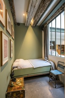 Dorien Knegt's vision comes to life in all areas of The Prinseneiland House. The window of this sage-colored bedroom faces into the interior of the home.