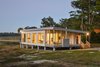 Modern home with Exterior, Green Siding Material, Metal Siding Material, Prefab Building Type, Flat RoofLine, Wood Siding Material, Tile Roof Material, Mid-Century Building Type, and Green Roof Material. Sunset shot Photo 2 of The Beatty Home