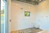 Modern home with Bath Room, One Piece Toilet, Engineered Quartz Counter, Concrete Floor, Porcelain Tile Wall, Ceiling Lighting, Open Shower, and Wall Mount Sink. Master Bathroom Photo 8 of The Beatty Home