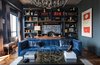 Modern home with Living Room, Sofa, Coffee Tables, Chair, Bookcase, Ceiling Lighting, Pendant Lighting, Medium Hardwood Floor, and Bench. LIVING ROOM & STUDY, West Wall
Custom made bookshelf & Library ladder: by Garret & Garage
Crafted in Walnut and brass by Imerio Palumbo.
Bookshelves paint color, Farrow & Ball “Railings,” ceiling Farrow & Ball, "Worsted"
Sconces by Studio VC
Brass sculpture on RH etched bronze coffee table, titled "Cleopatra" by Roger Stevens" - Gallery Timothy Yarger Fine Art
Italian bronze foot, ma+39, Los Angeles
Art (behind desk):
People by Cuban artist residing in Havana, Luis Rodriguez Noa
Oil Stick, Acrylic, and Ink on canvas
Art (right):
I Never Forget What I Can’t Remember by Harland Miller, England
Wall color: Farrow & Ball "Downpipe"
Photo 2 of Eastern Columbia Loft