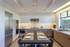 Modern home with Kitchen, Stone Counter, Engineered Quartz Counter, White Cabinet, Wood Cabinet, Porcelain Tile Floor, Ceramic Tile Backsplashe, Recessed Lighting, Refrigerator, Wall Oven, Cooktops, Range Hood, Dishwasher, Microwave, and Undermount Sink. kitchen Photo 7 of Legal House