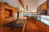 Modern home with Kitchen, Granite Counter, Wood Cabinet, Medium Hardwood Floor, Glass Tile Backsplashe, Ceiling Lighting, Dishwasher, Range, Range Hood, Pendant Lighting, Microwave, and Undermount Sink. Kitchen Photo 13 of High Desert Pavillion
