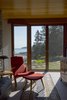 Modern home with Living Room, Chair, Table Lighting, Limestone Floor, Console Tables, Media Cabinet, and Lamps. Sitting room directly off the entry with view beyond Photo 8 of Deep Cove House