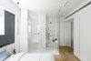 Modern home with Bed, Dresser, Storage, Chair, Ceiling Lighting, Wall Lighting, Pendant Lighting, and Medium Hardwood Floor. Master bed room overlooking en-suit classic-European style bathroom sectioned off with a curtain for privacy. Photo 12 of Colorfull in the white city