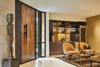 Modern home with Living Room, Chair, Coffee Tables, Ceiling Lighting, and Limestone Floor. Entry way of home and formal living / wine room. Photo 8 of Bent Tree Residence