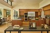Modern home with Kitchen, Wood Cabinet, Wall Oven, Drop In Sink, Microwave, Refrigerator, Ceiling Lighting, Ceramic Tile Backsplashe, Dishwasher, Marble Counter, Range, Light Hardwood Floor, and Recessed Lighting. Kitchen view, taken from main living room. Photo 11 of Bent Tree Residence