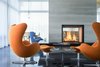 Modern home with Living Room, Chair, Pendant Lighting, Concrete Floor, Gas Burning Fireplace, Two-Sided Fireplace, Coffee Tables, and Ottomans. Porcelanosa Tile Chimney in Great Room Photo 4 of The Landing
