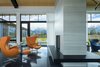 Modern home with Living Room, Chair, Ottomans, Ceiling Lighting, Concrete Floor, Gas Burning Fireplace, Two-Sided Fireplace, and Recessed Lighting. Sitting Area with floating steel hearth Photo 8 of The Landing