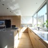 Modern home with Kitchen, Wood Cabinet, Engineered Quartz Counter, White Cabinet, Light Hardwood Floor, Stone Slab Backsplashe, Ceiling Lighting, Pendant Lighting, Refrigerator, Wall Oven, Cooktops, Dishwasher, and Undermount Sink. Kitchen Photo 10 of The Edge House