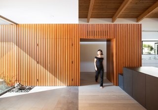 Douglas fir cladding that leads into the foyer conceals the garage, which is a 24-foot-wide, top-hung, bi-fold door.