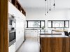 Modern home with Kitchen, Light Hardwood Floor, Cooktops, Ceiling Lighting, Wood Counter, Microwave, Pendant Lighting, Refrigerator, White Cabinet, Wall Oven, and Drop In Sink. white/wood kitchen Photo 3 of Résidence à Stoneham
