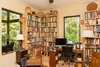 Modern home with Office, Chair, Study, Bookcase, Storage, Shelves, Desk, Lamps, and Medium Hardwood Floor. The study is filled with Native American art and artifacts, along with a book collection. Photo 15 of Professor's House