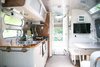 Modern home with Kitchen, Drop In Sink, Recessed Lighting, Ceiling Lighting, Metal Counter, and Wall Oven. With its peaceful environment and abundance of amenities, Caravan Outpost can comfortably accommodate the needs of guests for their entire stay. Photo 6 of Airstream Caravan Outpost