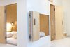Modern home with Bedroom, Bed, Light Hardwood Floor, and Wall Lighting. The architect, Sigurd Larsen, aligned the openings in the walls to maximize natural light in the room. The folding doors, hatches, and windows of varying shapes and sizes encourage play.
"With this room you get a whole house," says Larsen. "Pure and calm from the outside, the many doors and windows reveal a warm wooden interior." Photo 3 of Michelberger Hotel