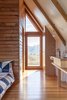 Modern home with Bedroom, Medium Hardwood Floor, Pendant Lighting, and Bed. The whitewashed shiplap Silvertop Ash sloped walls contrasts with the v-groove pine that wraps around the bathroom. Photo 11 of Kimo Estate