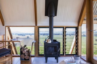 A freestanding Nectre wood-burning stove provides extra warmth in winter, while operable louvers let in cooling breezes in summer.  