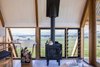 Modern home with Living Room, Wood Burning Fireplace, Medium Hardwood Floor, Chair, Desk, and Coffee Tables. A freestanding Nectre wood-burning stove provides extra warmth in winter, while operable louvers let in cooling breezes in summer. Photo 6 of Kimo Estate