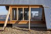 Modern home with Exterior, Cabin Building Type, Wood Siding Material, A-Frame RoofLine, and Metal Roof Material. The A-frame structure is elevated on pad footings. Photo 9 of Kimo Estate