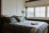 Modern home with Bedroom, Bed, and Medium Hardwood Floor. In the main bedroom, the couple have built the king-size bed frame out of recycled timber. Photo 10 of The Little Black Shack