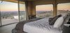 Modern home with Bedroom, Bed, Medium Hardwood Floor, Rug Floor, Table Lighting, and Night Stands. Guests wake up to views overlooking undulating hills and ridges. Photo 9 of Sierra Escape