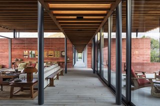 An east-facing view of the central circulation hallway is flanked with full-height, dark-gray anodized aluminum windows.

