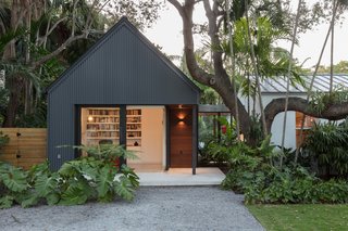 This gabled addition by Upstairs Studio Architecture is topped with a standing seam metal roof and is clad in vertical corrugated metal siding. 