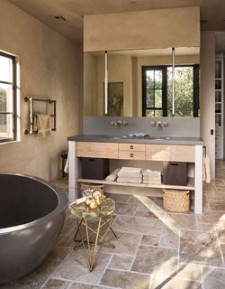 Modern bathroom fixtures are paired with rustic, natural materials. 