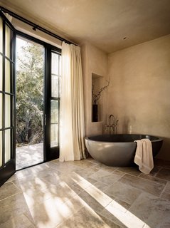 The master bath features a rounded, freestanding bath.