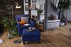 Modern home with Chair and Medium Hardwood Floor. A Rotterdam Club Chair and Ottoman anchor this cozy corner of the living space, while an exposed timber wall and pockets of greenery bring the outdoors in. Photo 11 of Ravendere Retreats