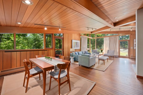 A vaulted ceiling delivers drama to the great room, which brings the outdoors in through floor-to-ceiling, mitered windows set in dramatic angles.