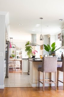 The renovation created a lighter, more open atmosphere with views extending from the dining room through the kitchen and to the living space in the rear. To break up the rooms, the couple replaced the wood kitchen floors with staggered tile from Arizona Tile.