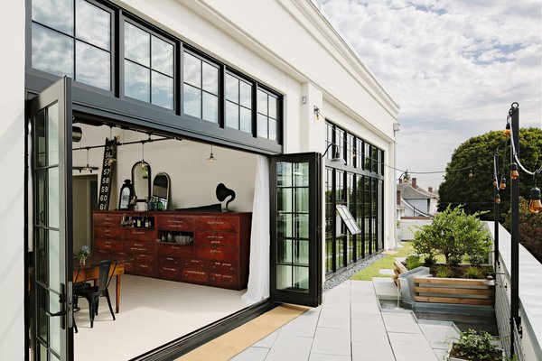 Bi-fold sliding Marvin doors recall steel-framed factory windows, yet are actually built of black-painted wood and insulated glass.